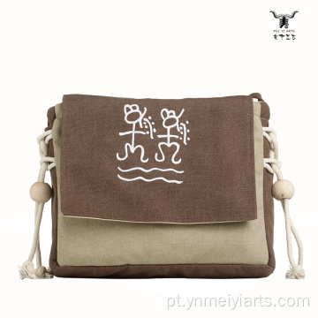 Bolsa crossbody de lona com símbolo primitivo Mei Yi Arts
